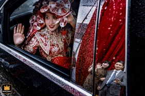 A documentary-style photograph captures an emotional scene at a home in Fujian, China. The image shows the bride's parents saying goodbye to her, highlighting the poignant final moments before the wedding.